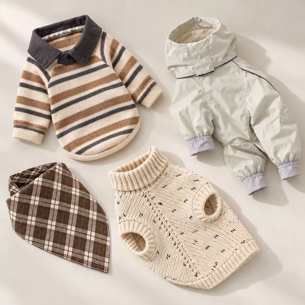 Pet apparel and accessories including a striped dog shirt, a knitted sweater, a light pet coat and plaid bandana.