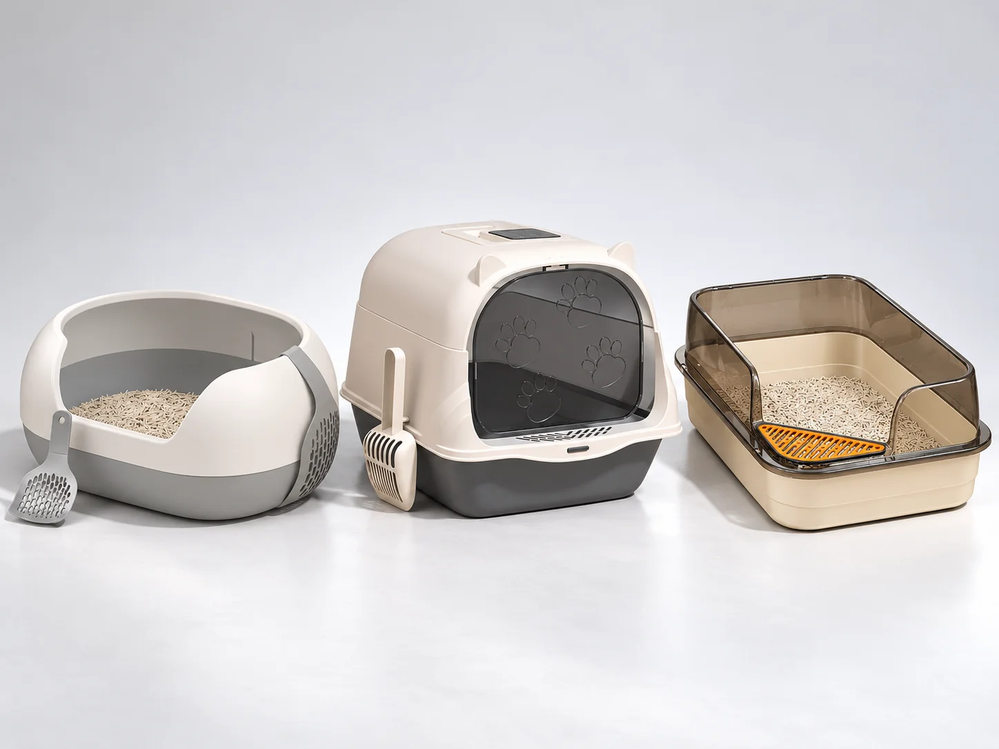 Three cat litter box designs: grey high-sided open tray, beige front-door hooded box and cream open-top tray with clear splash guard