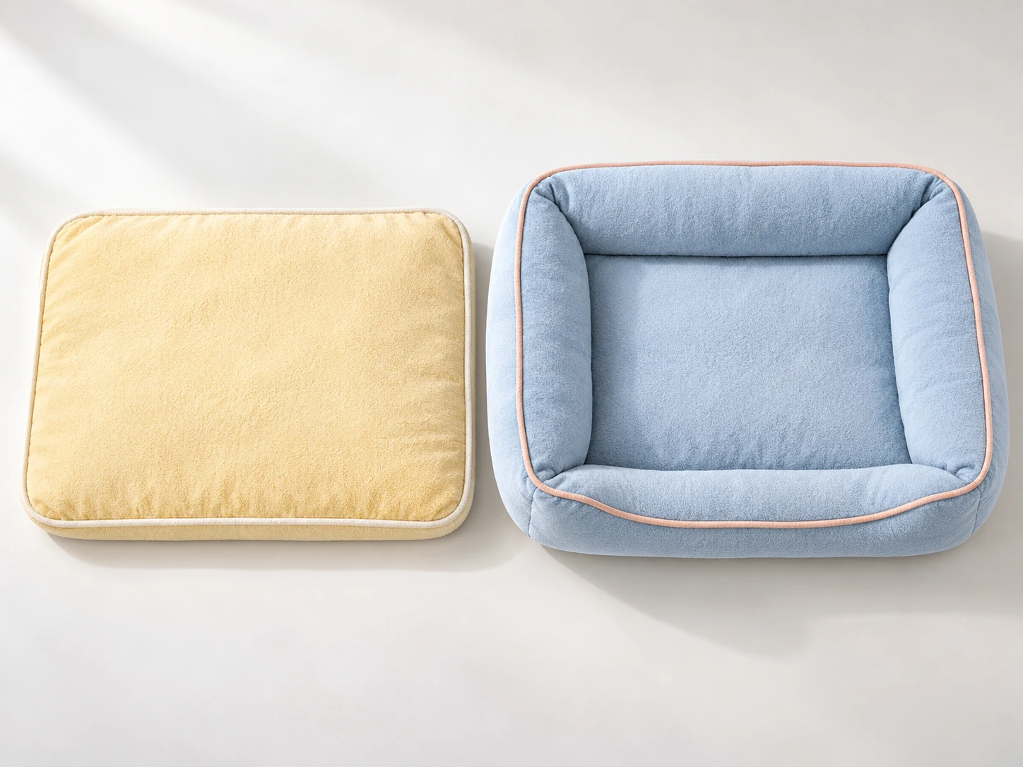 Yellow flat dog mattress beside a larger blue bolster bed with a smaller central sleeping area