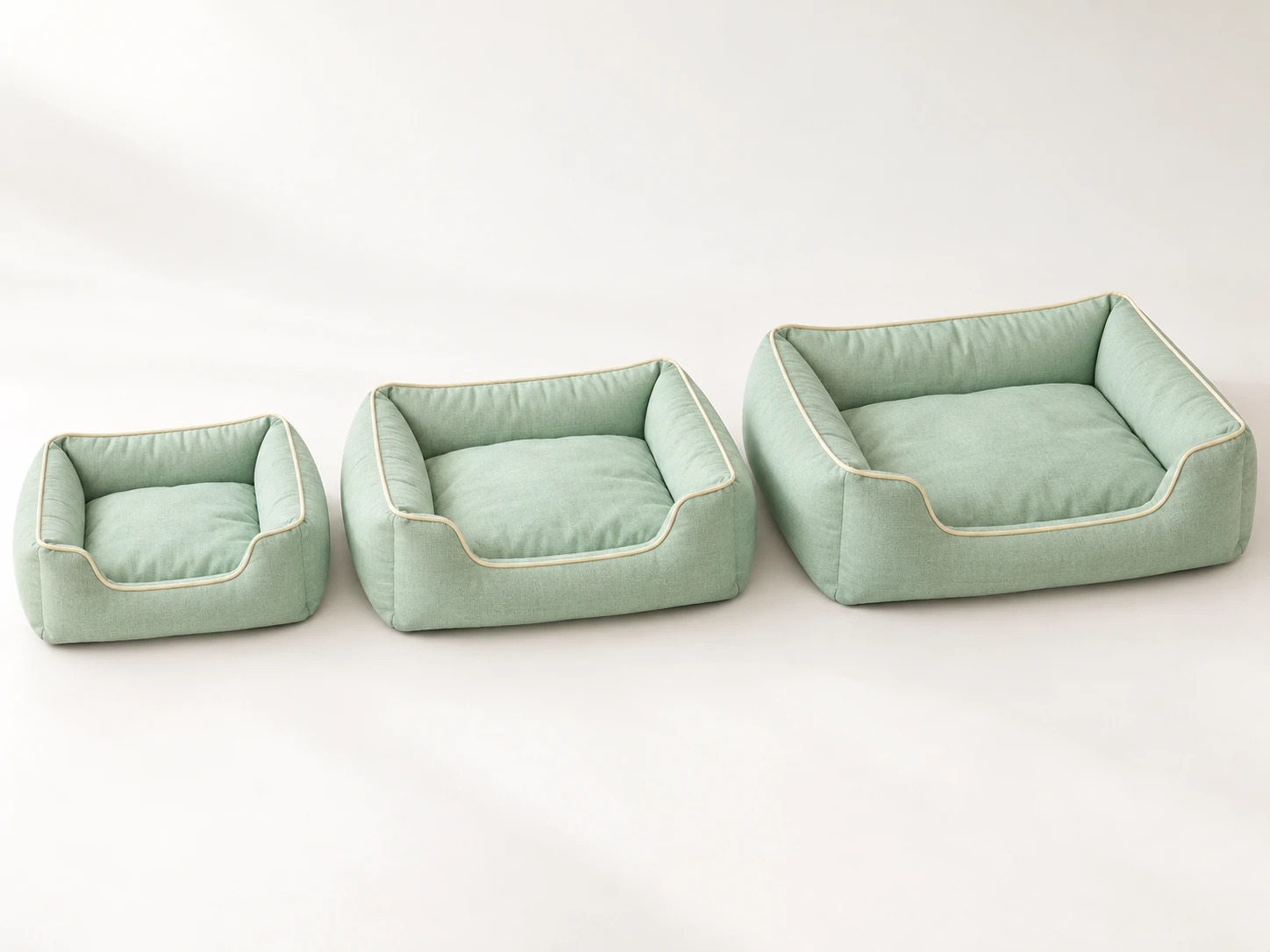 Three matching mint-green bolster dog beds in progressively larger sizes