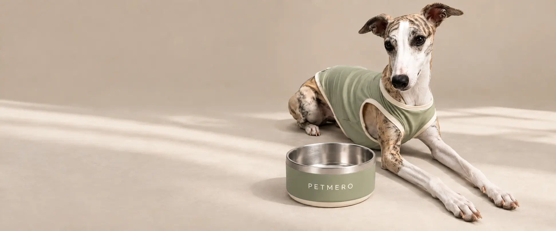 Dog beside a metal dog bowl.
