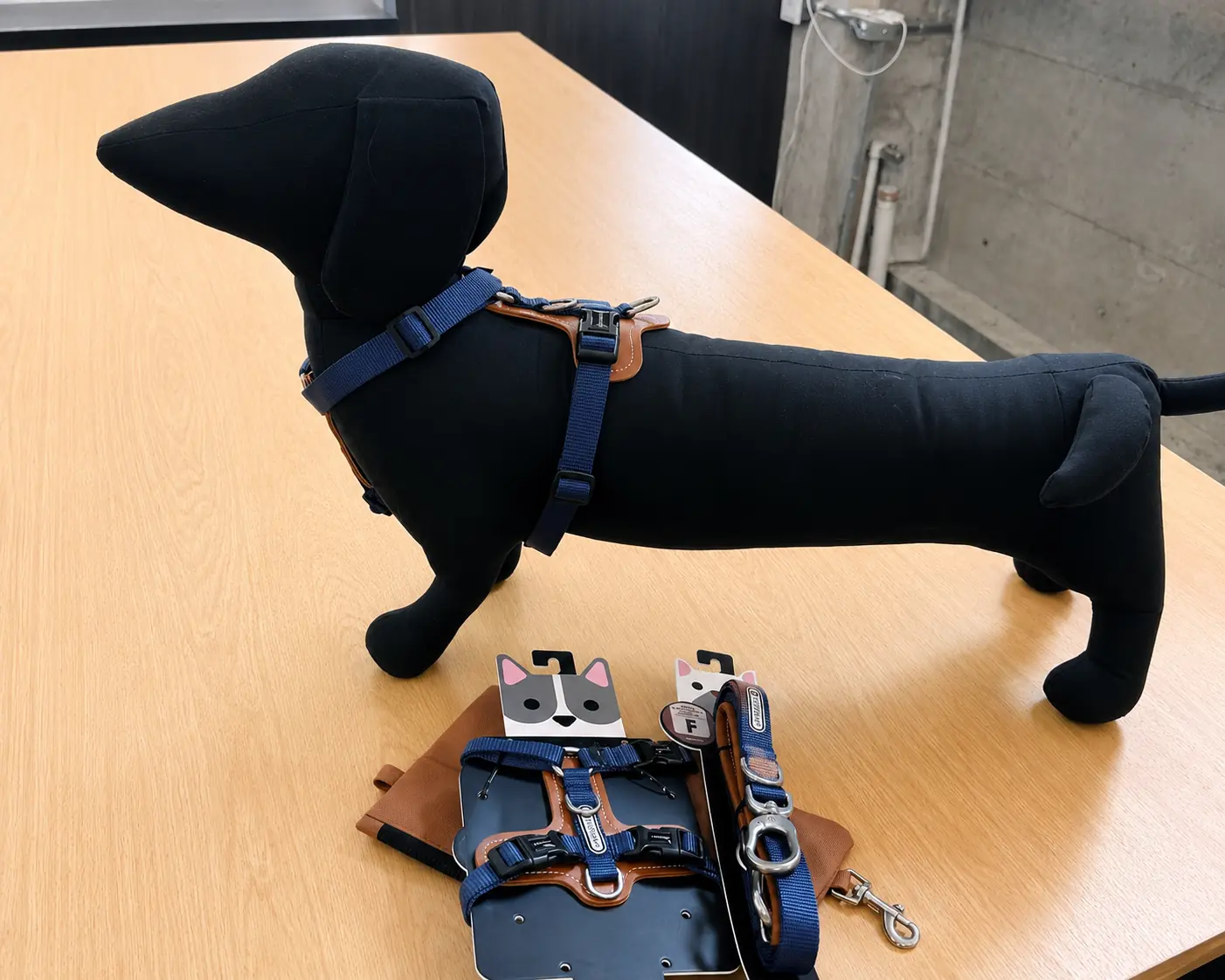 Dog harness and leash samples displayed beside a dog mannequin wearing a harness.