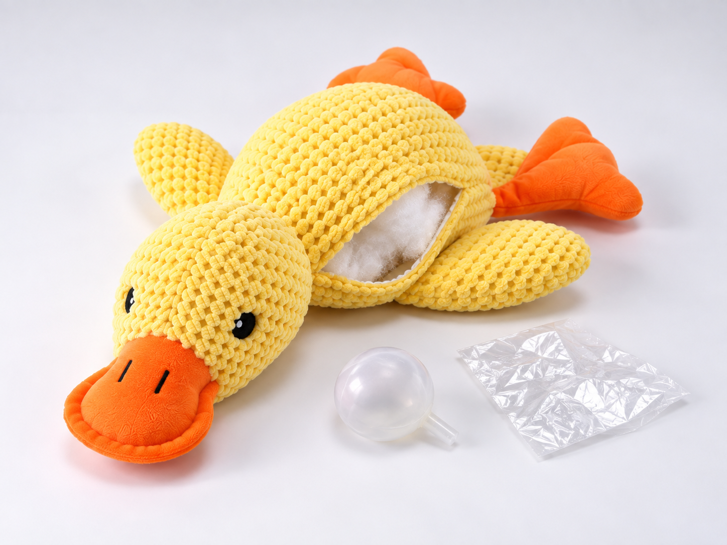 Yellow plush duck dog toy showing stuffing, a squeaker and a crinkle insert.